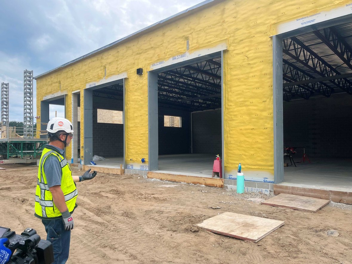 School District of Rhinelander Construction Project Progress Update with CD Smith Superintendent in front of partially completed Auto Lab with new roof and concrete floor on Wisconsin jobsite