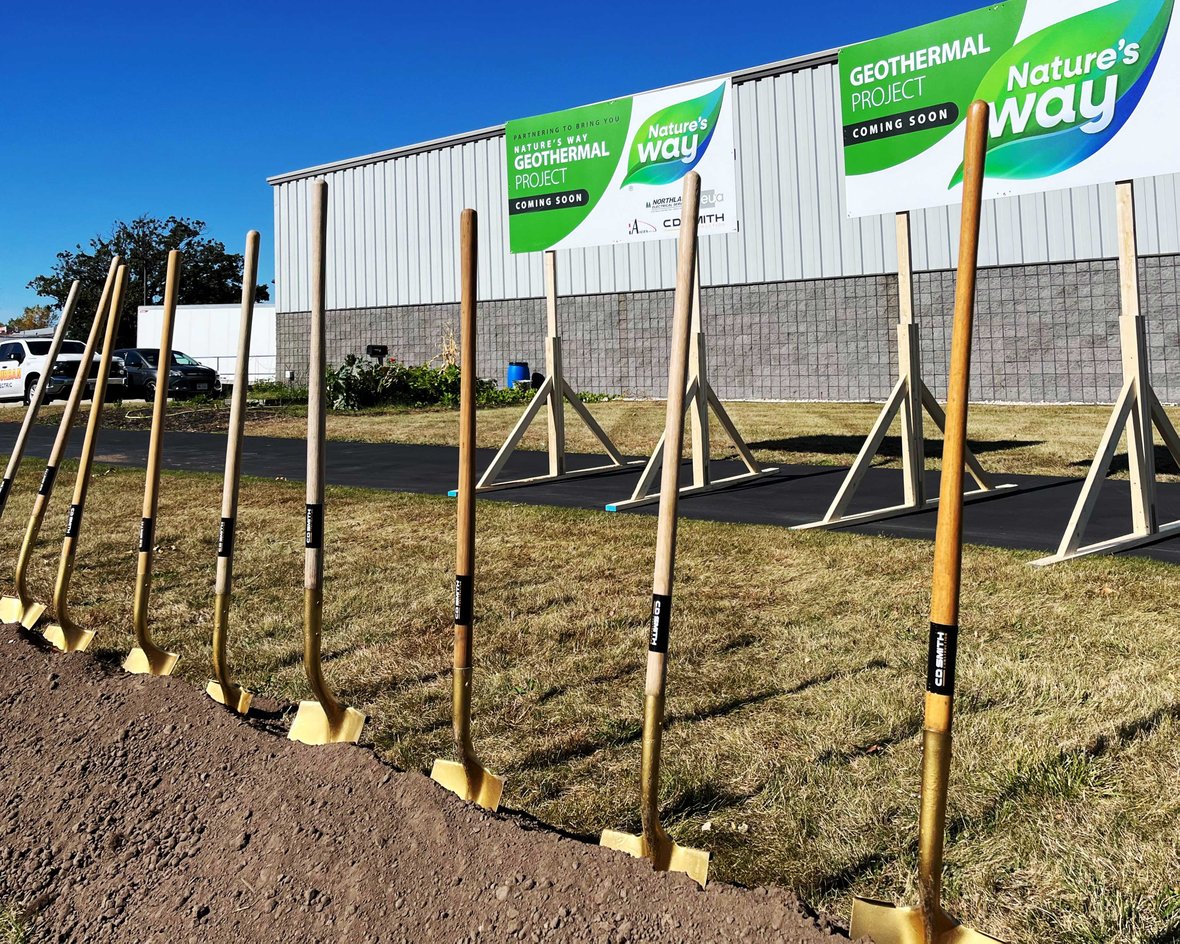 Groundbreaking ceremony setup for Nature’s Way $12M geothermal project in Green Bay, WIsconsin featuring shovels and project signage.