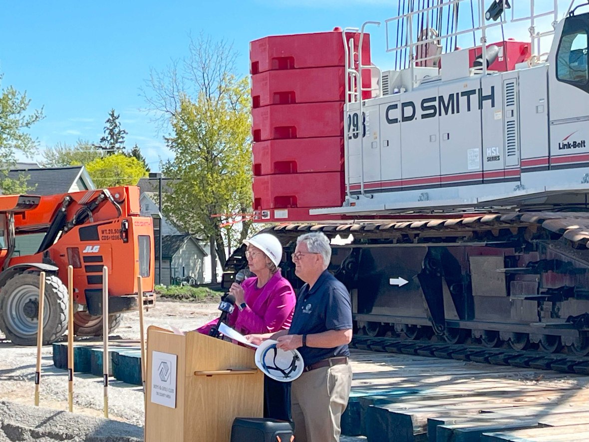 Speaker at podium for Boys & Girls Club of the Tri County Area at groundbreaking for Ripon facility with CD Smith Construction crane in background