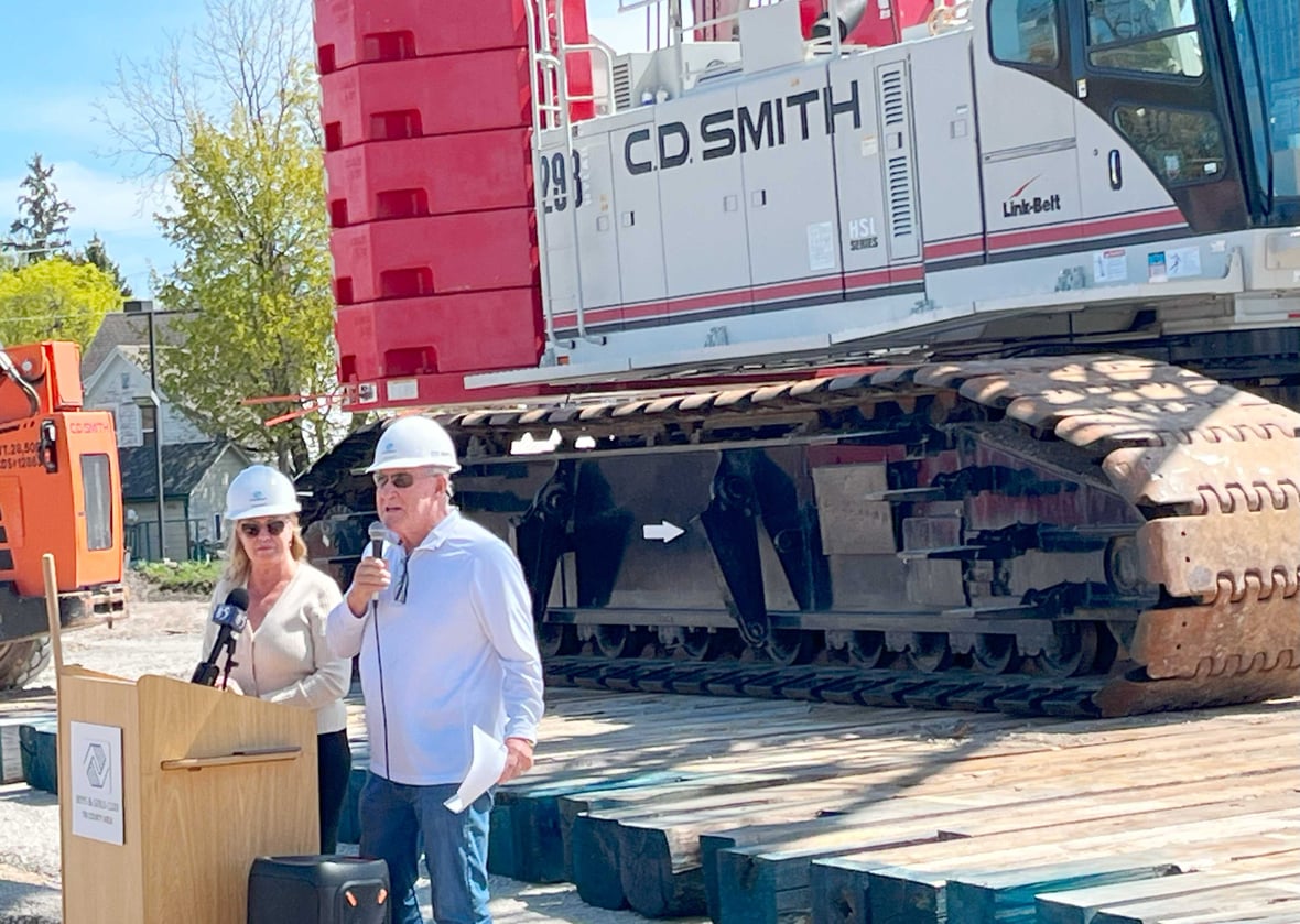 Speaker at podium for Boys & Girls Club of the Tri County Area at groundbreaking for Ripon facility with CD Smith Construction crane in background