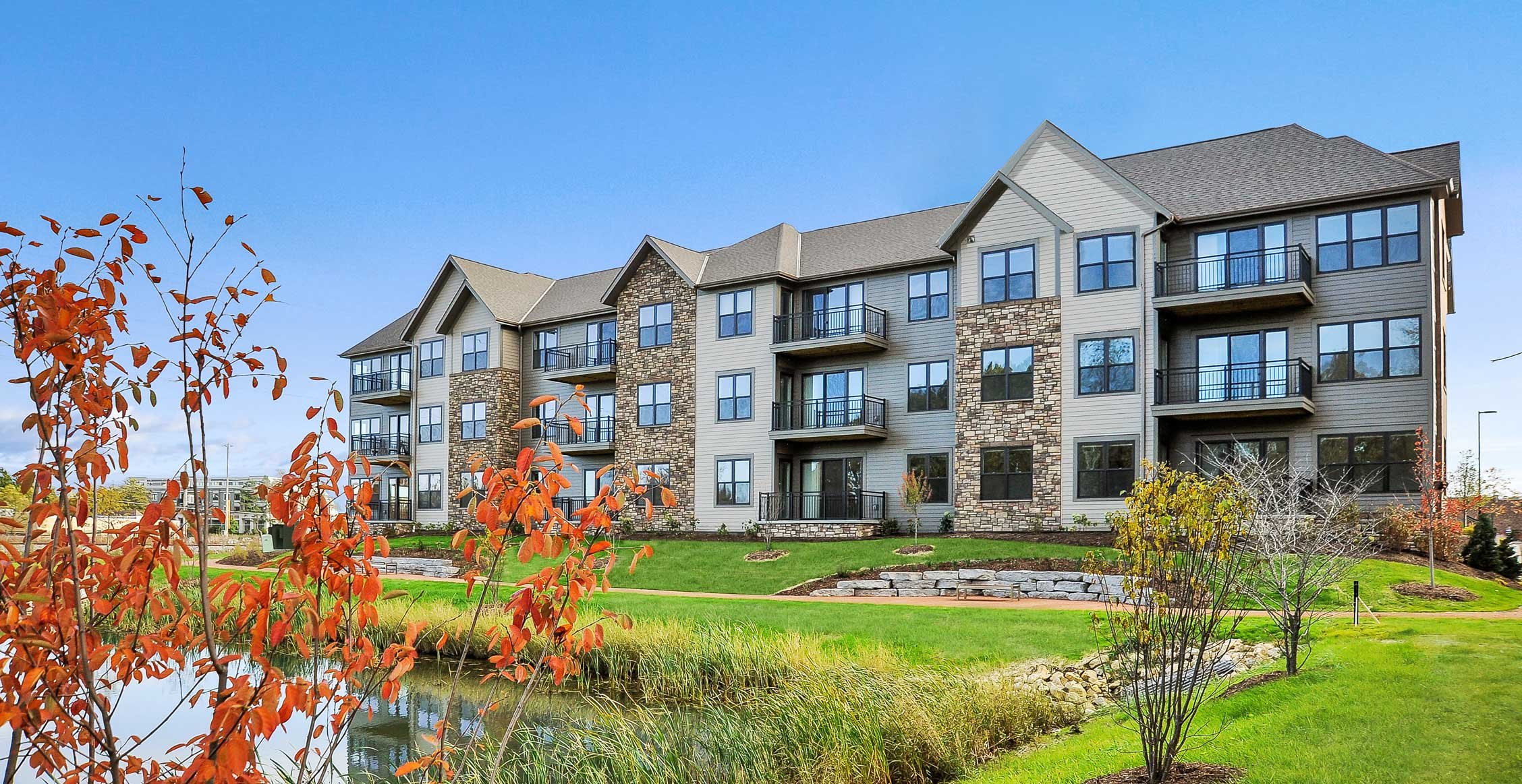 Street view of Spur 16 residential building with balconies and landscaping in Mequon, Wisconsin.
