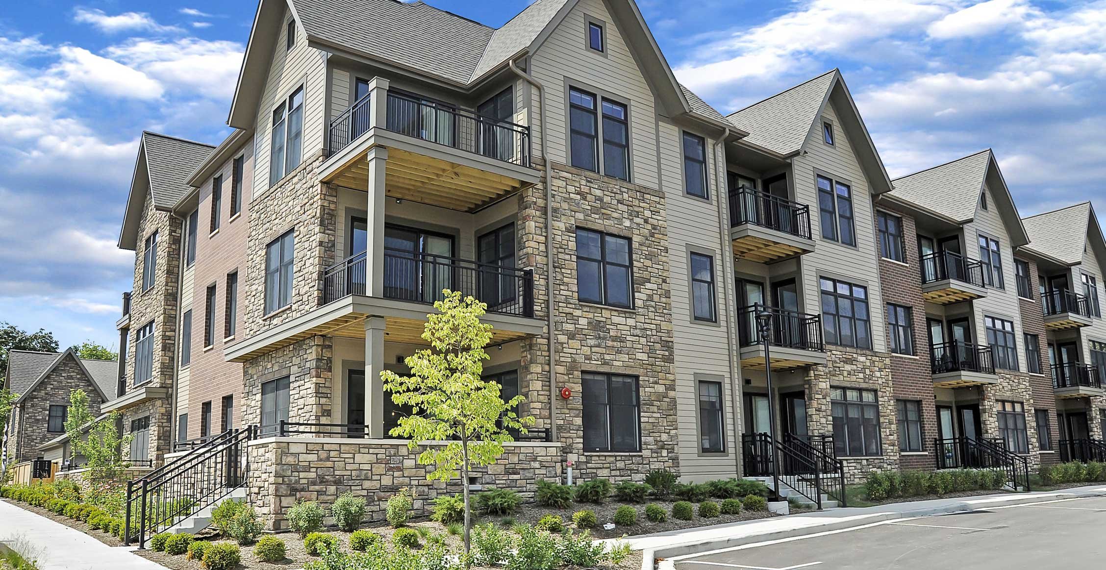 Exterior view of Spur 16 apartments with stone and siding facade and private balconies.