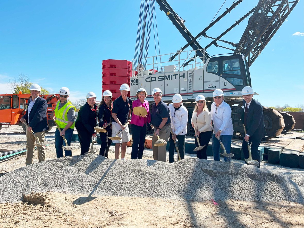 Stakeholders shoveling at groundbreaking for Ripon Boys & Girls Club with Wisconsin CD Smith Construction crane in background