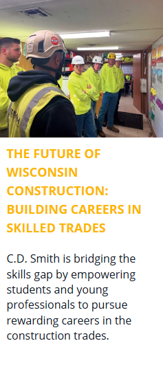 Students tour a C.D. Smith commercial construction jobsite trailer in Wisconsin, observing a pull planning schedule and learning about project management and skilled trades careers.