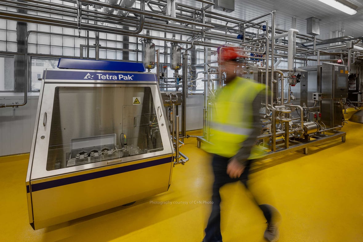 Food Processing and Packaging equipment in background with construction worker in foreground in dairy plant production facility at UW Babcock Hall