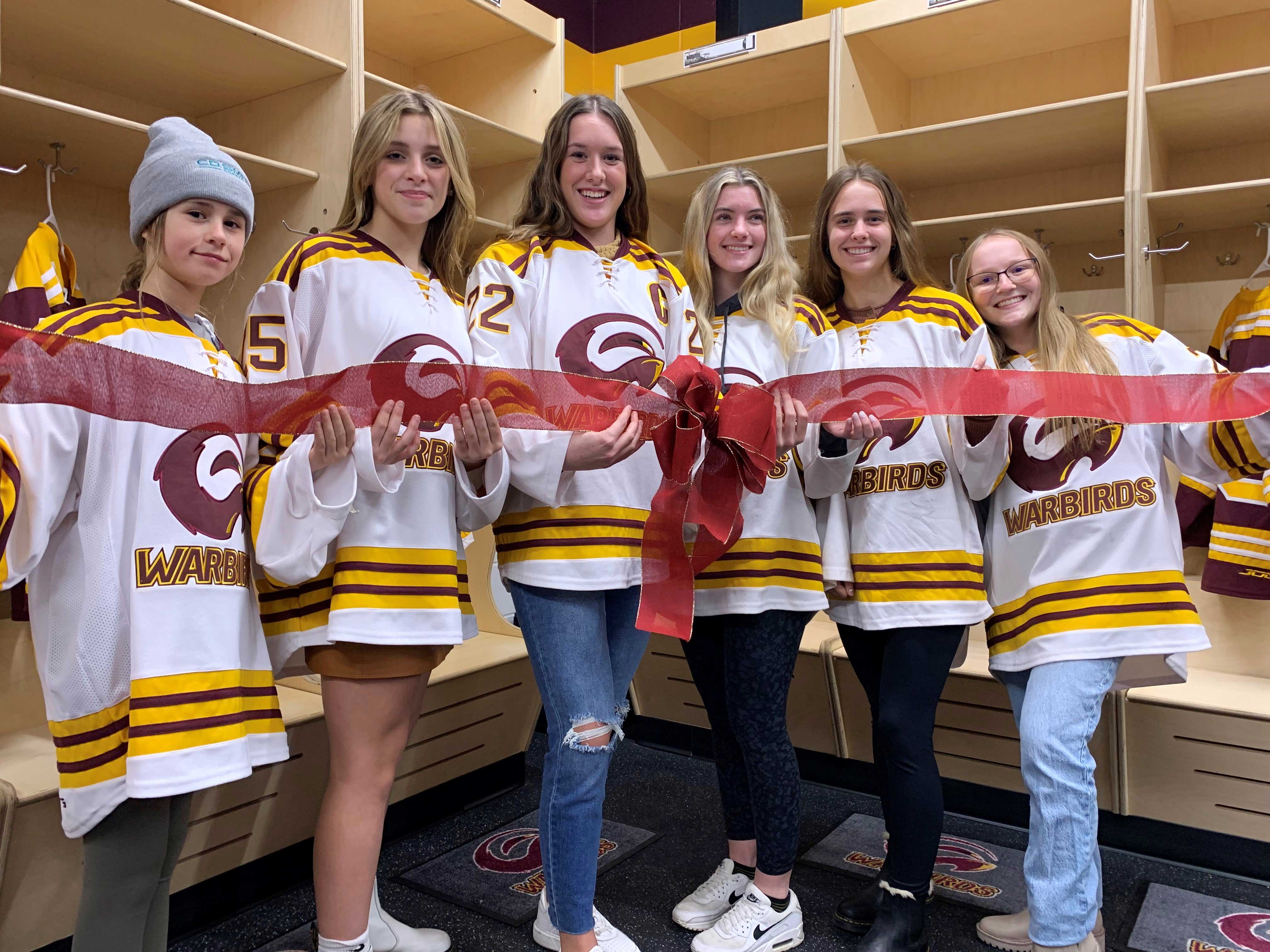 Warbirds ladies ribbon cutting girls by locker room cubbies after addition and renovation project at Blue Line Family Ice Center with CD Smith Construction