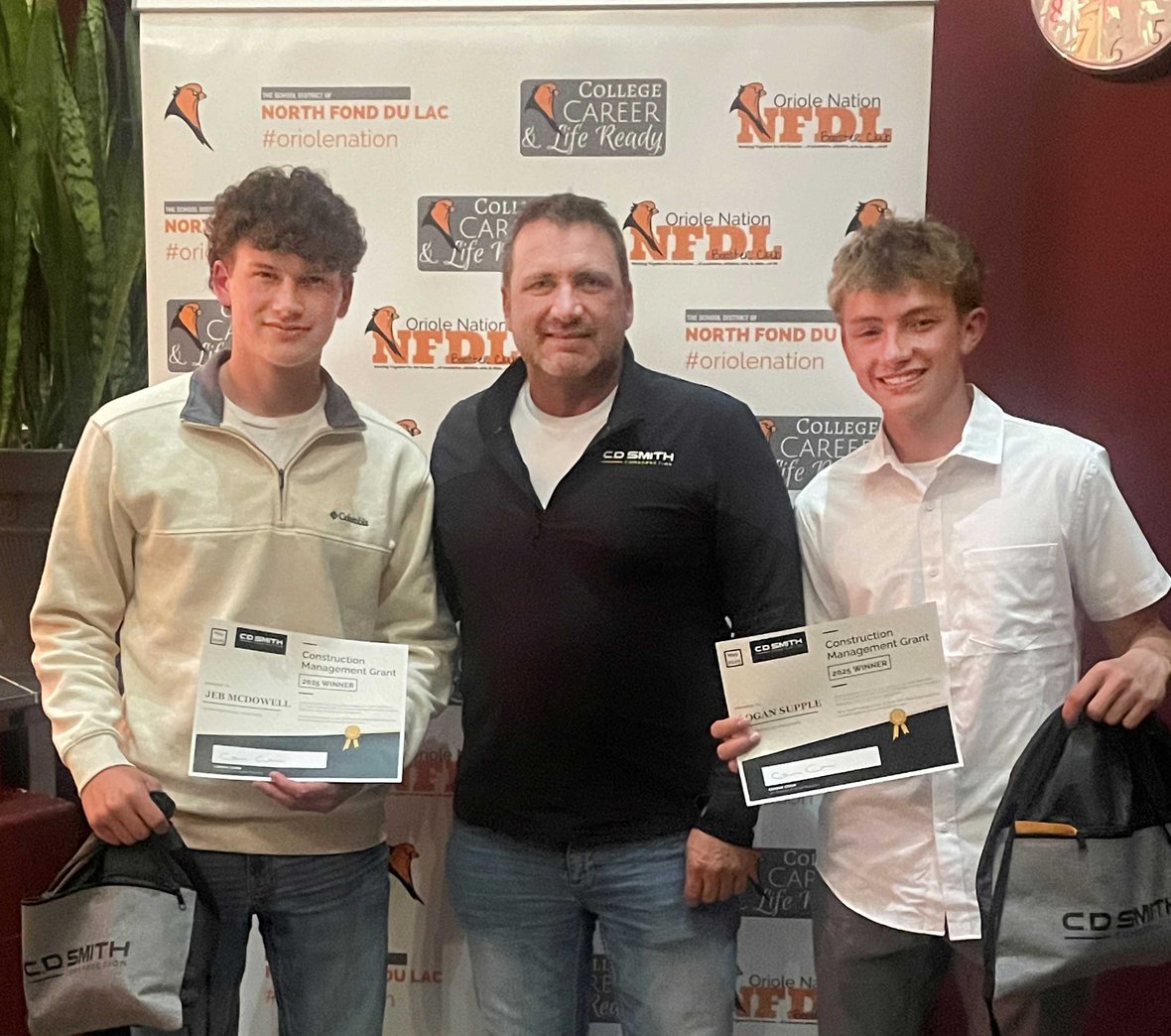 Jeb McDowell, Dave Supple from C.D. Smith, and Logan Supple at North Fond du Lac High School awards ceremony, celebrating construction management grant achievements in Wisconsin.