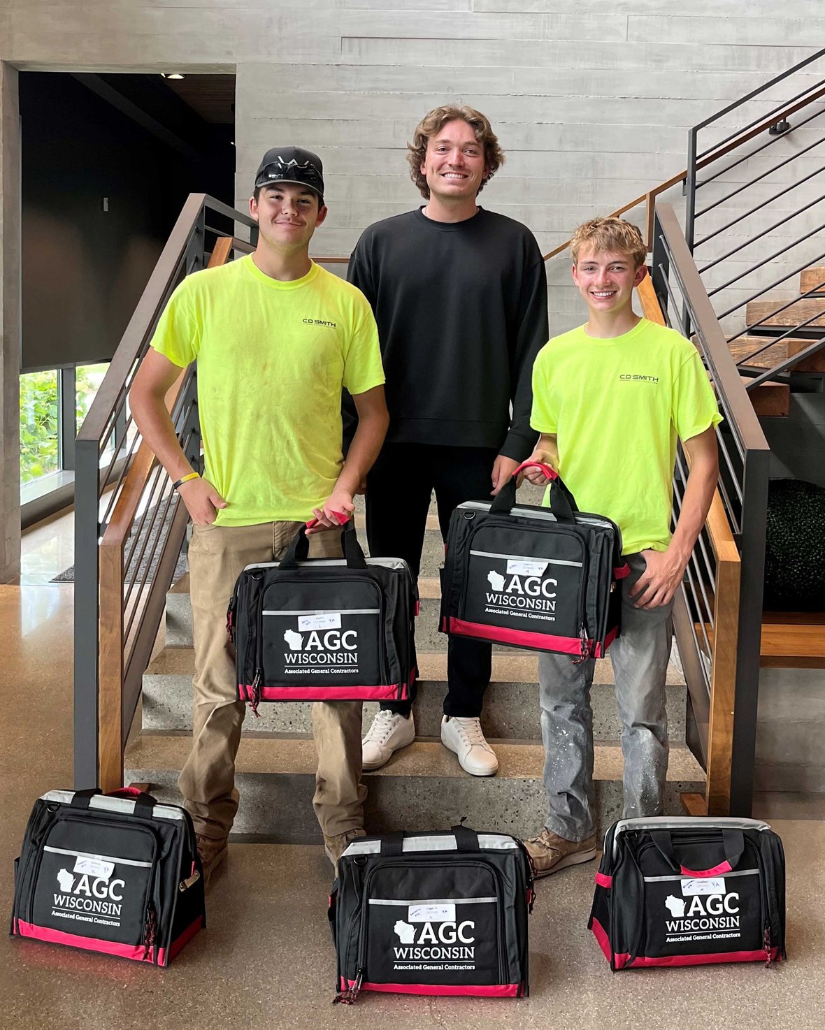 Wisconsin construction youth apprentices receiving AGC of Wisconsin starter kits at a commercial construction office, supporting hands-on training and skilled trades career development in the state.