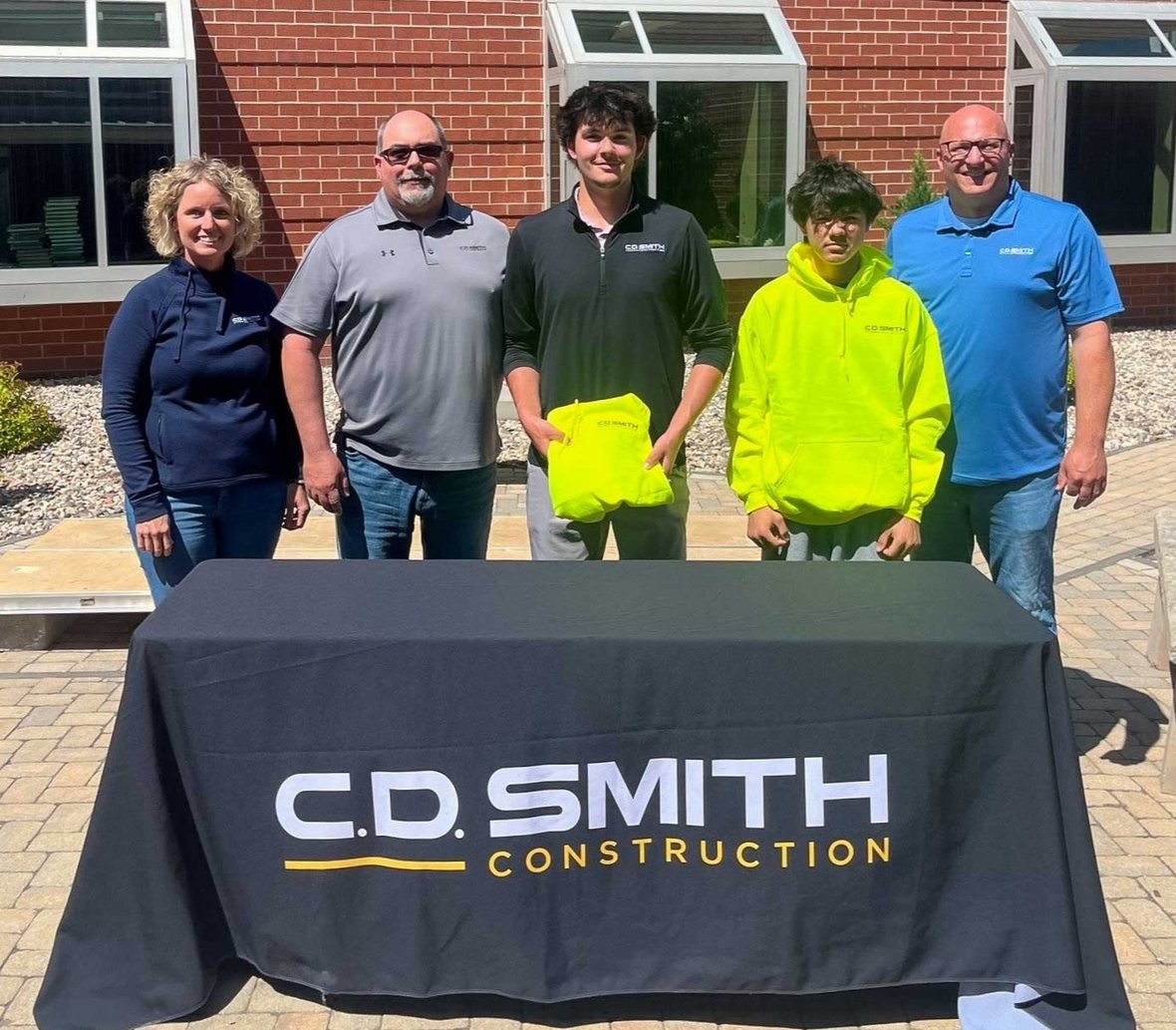 ACE Academy students Aaden Richardson and Antonio Flores with C.D. Smith Construction representatives during a signing day event recognizing construction career pathways and youth apprenticeship opportunities.
