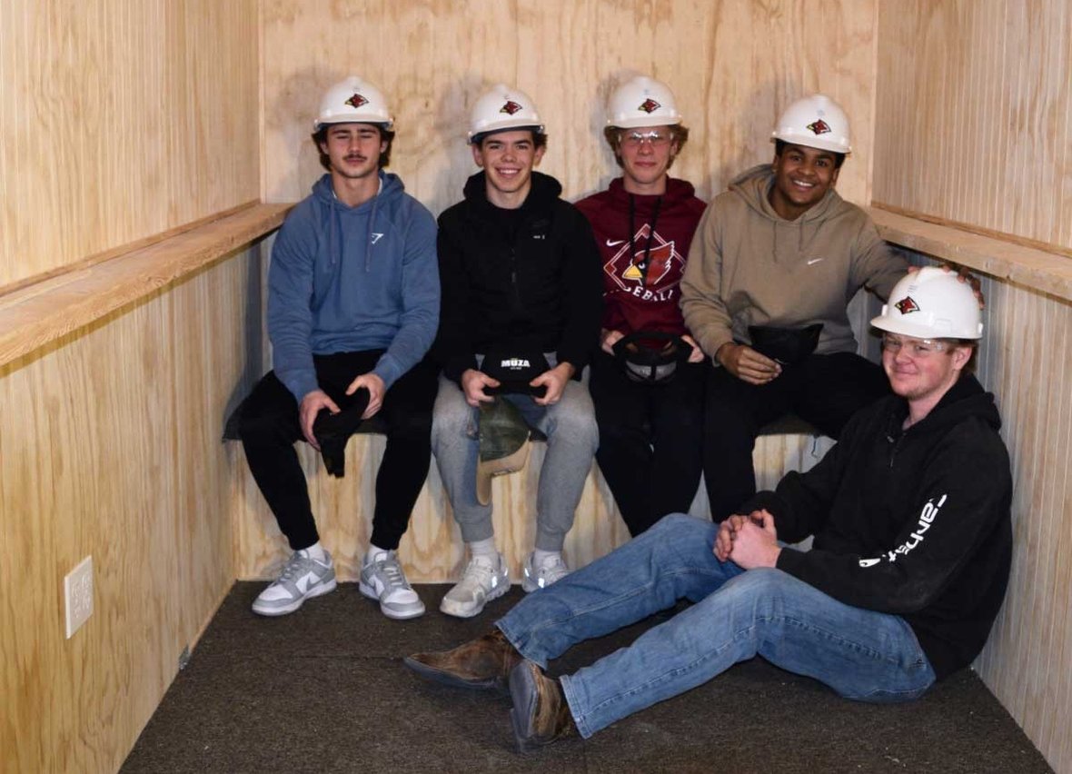 Students from Fond du Lac High School ACE Academy sit inside a finished ice shanty they built as part of a hands on construction project