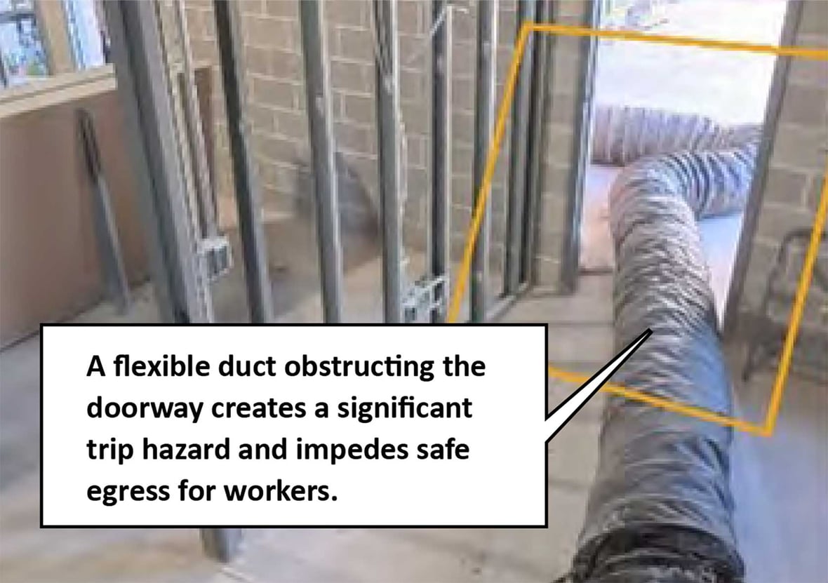 AI-identified flexible ventilation duct creating a trip hazard and obstructing a construction doorway.
