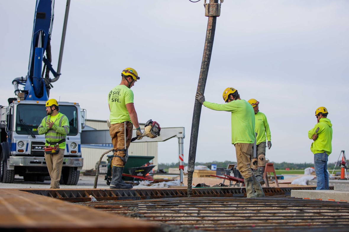 Construction crew placing concrete on-site with pump truck; C.D. Smith ProjectPlus team demonstrating safety and precision on self-perform concrete work.
