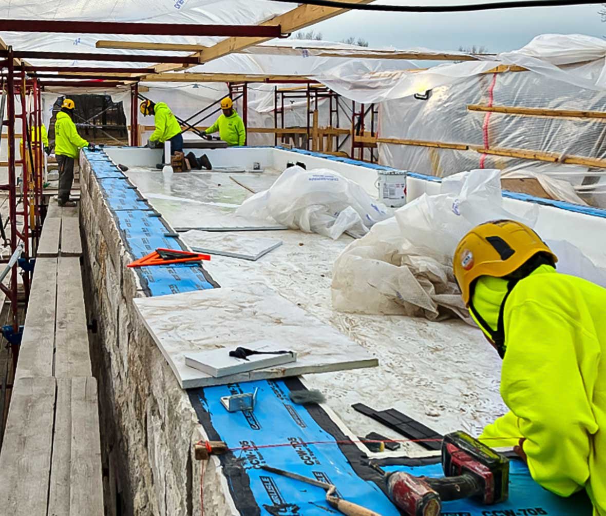 C.D. Smith masons installing decorative stonework during construction of the Grande Cheese greenhouse project.