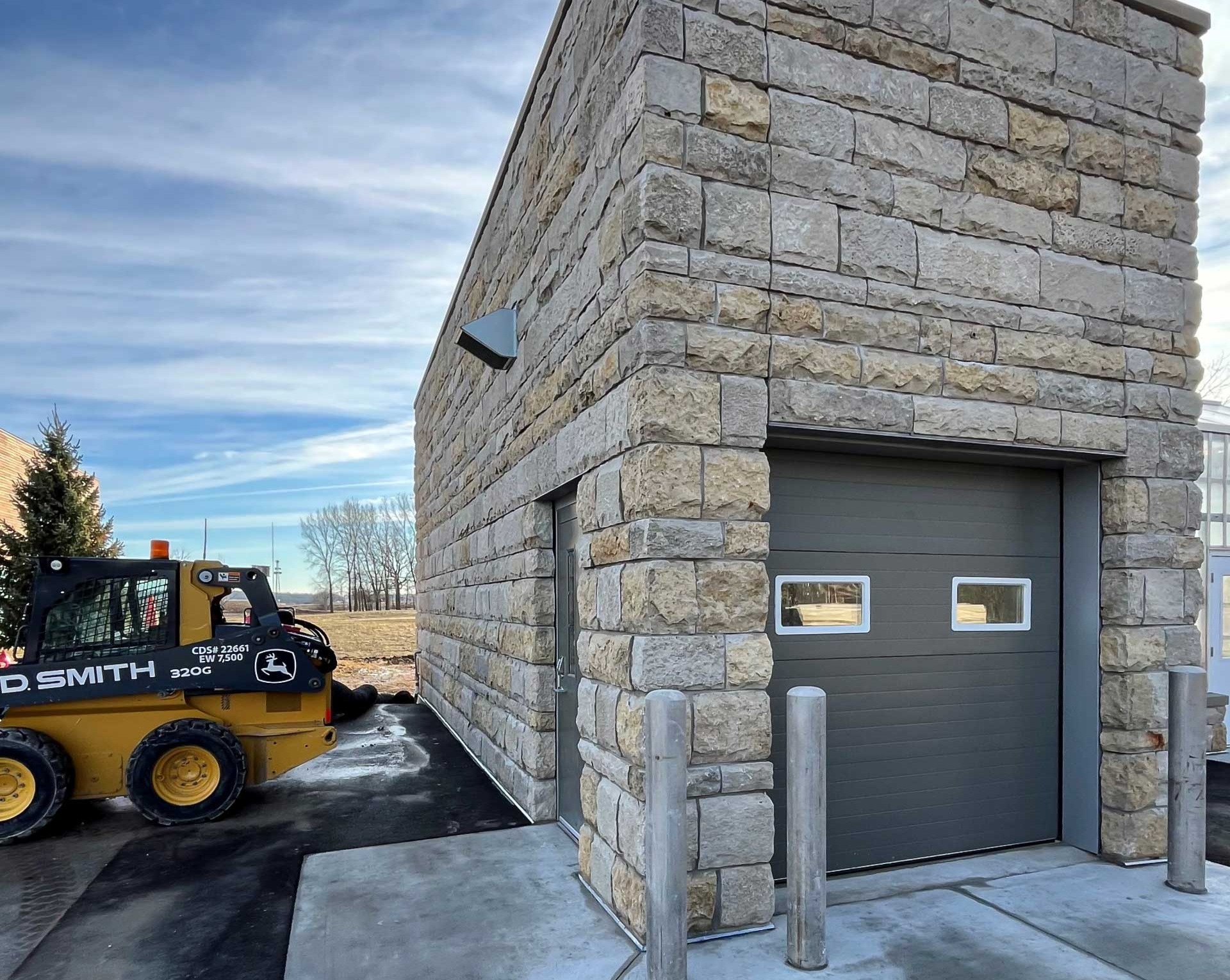 Matching stone maintenance building constructed alongside the commercial greenhouse at the Grande Cheese corporate campus.
