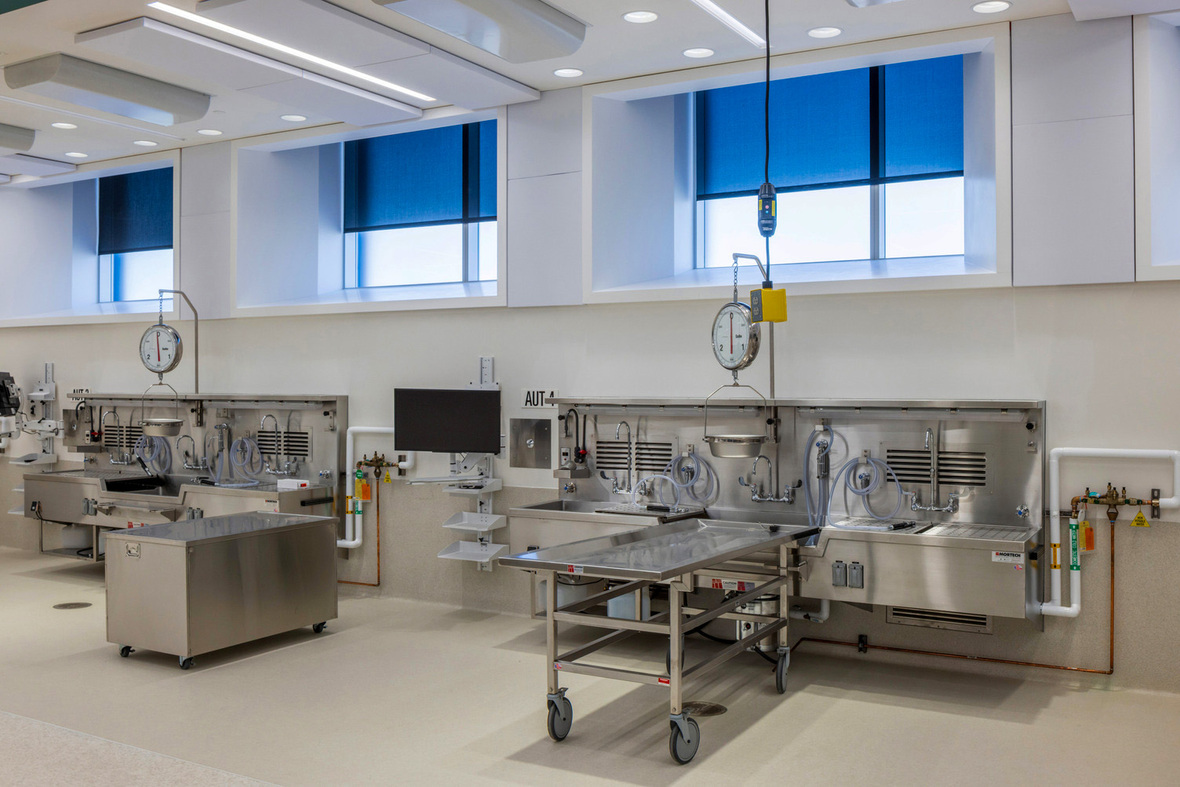 Autopsy suite with multiple stainless steel stations in the Milwaukee County Medical Examiner's Office.