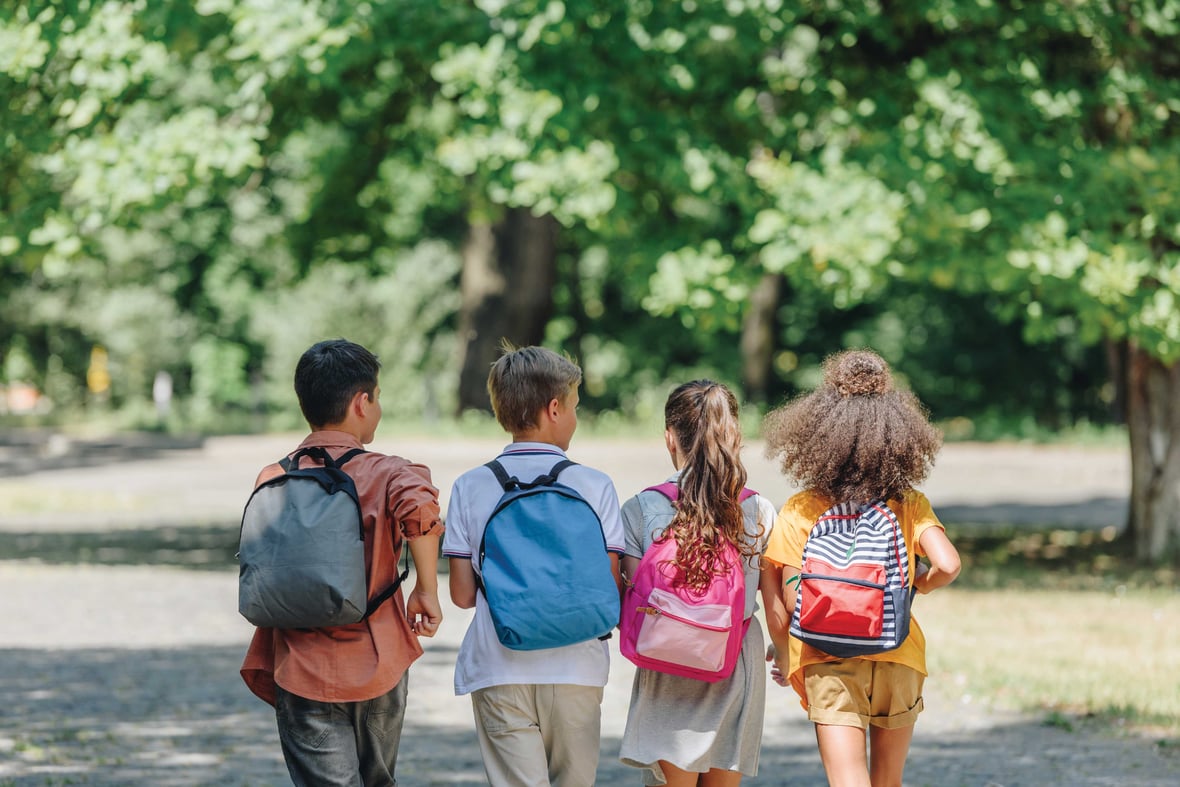 Back view of students walking toward Markesan District Schools, symbolizing safety and progress after summer repairs.