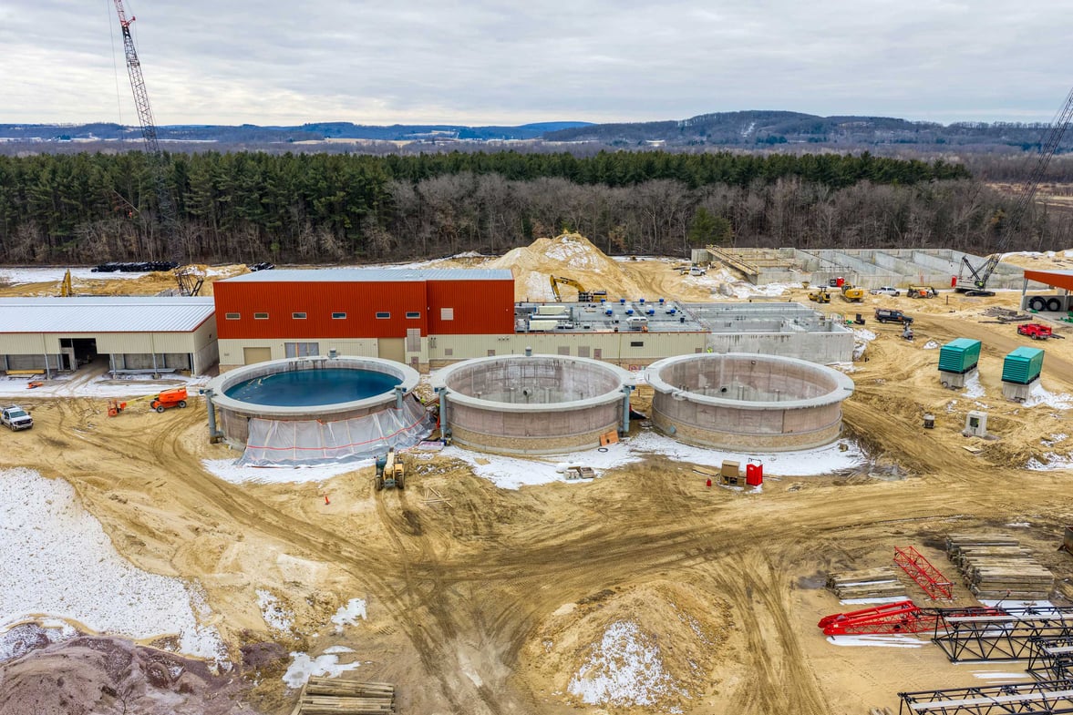 Aerial view of the Reedsburg Wastewater Treatment Plant construction site showing new treatment tanks and facility buildings under construction.