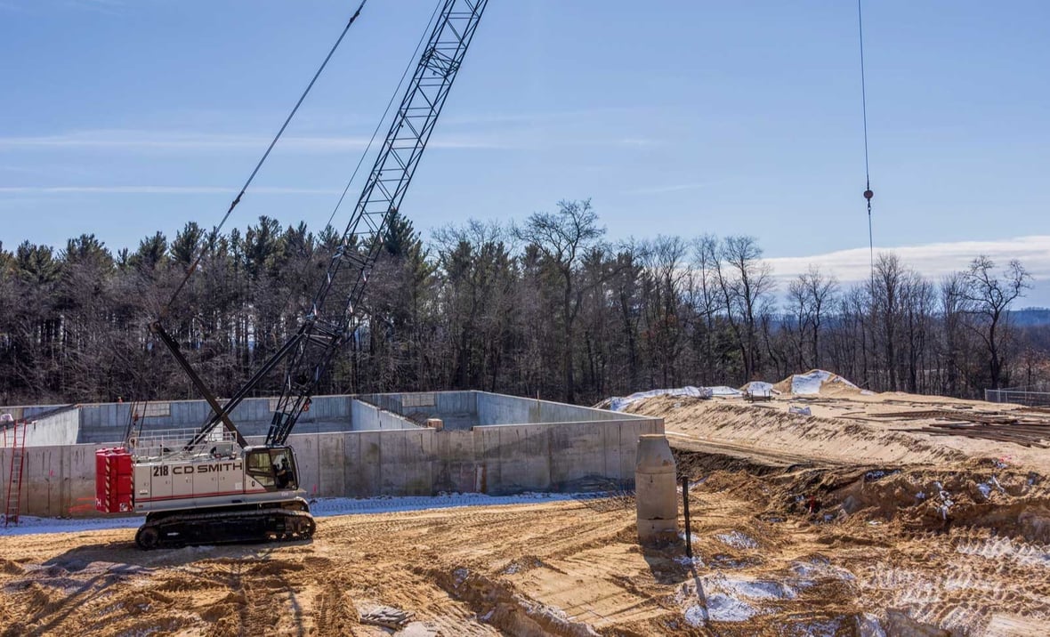 Crawler crane constructing concrete treatment structures at the Reedsburg Wastewater Treatment Plant project.