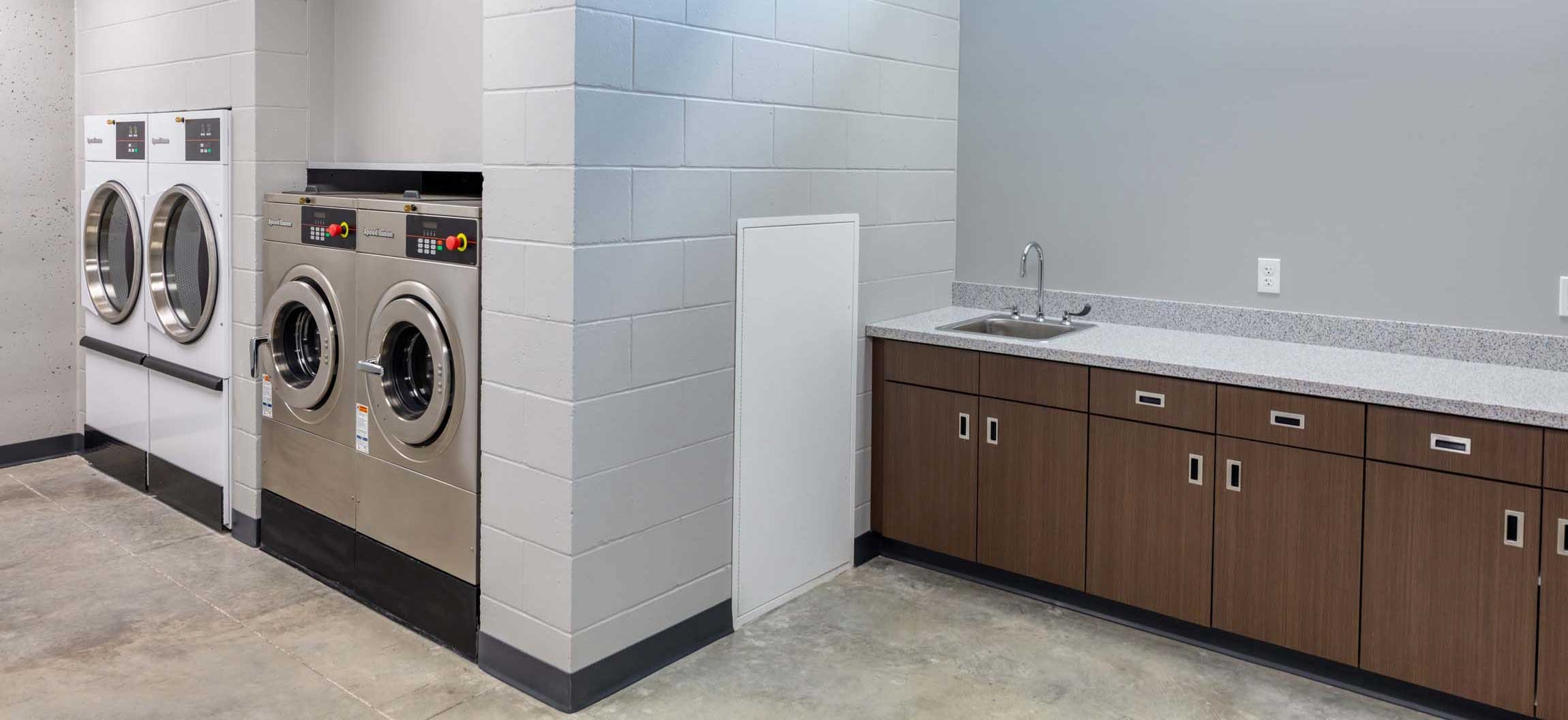 Laundry and support facilities inside the Ripon Boys & Girls Club with commercial washers dryers and built-in cabinetry