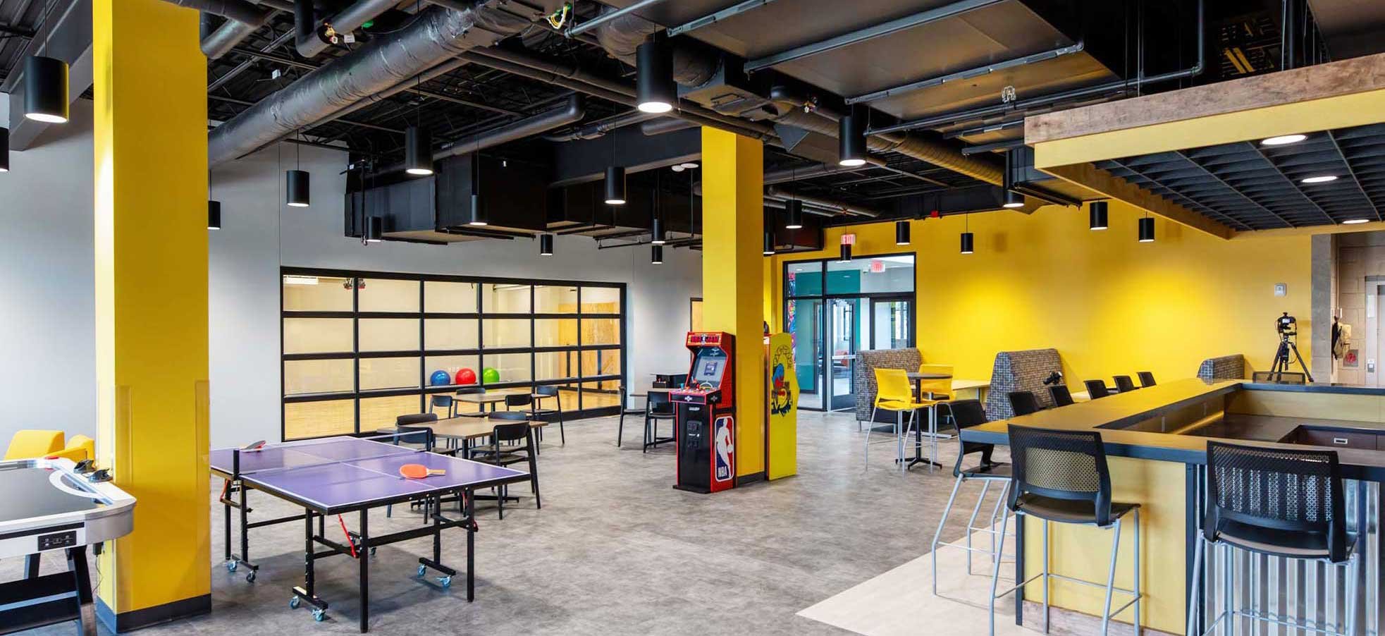 Teen recreation and employment center at the Ripon Boys & Girls Club featuring ping pong tables collaborative seating and open industrial ceiling