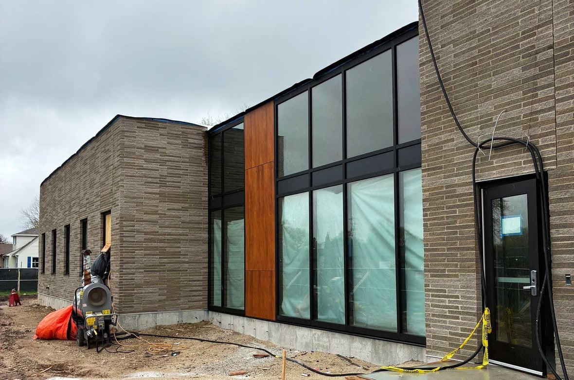 Exterior view of the SSM Health Cancer Care expansion showing completed brick facade curtainwall glazing and wood panel accent nearing completion in Fond du Lac.