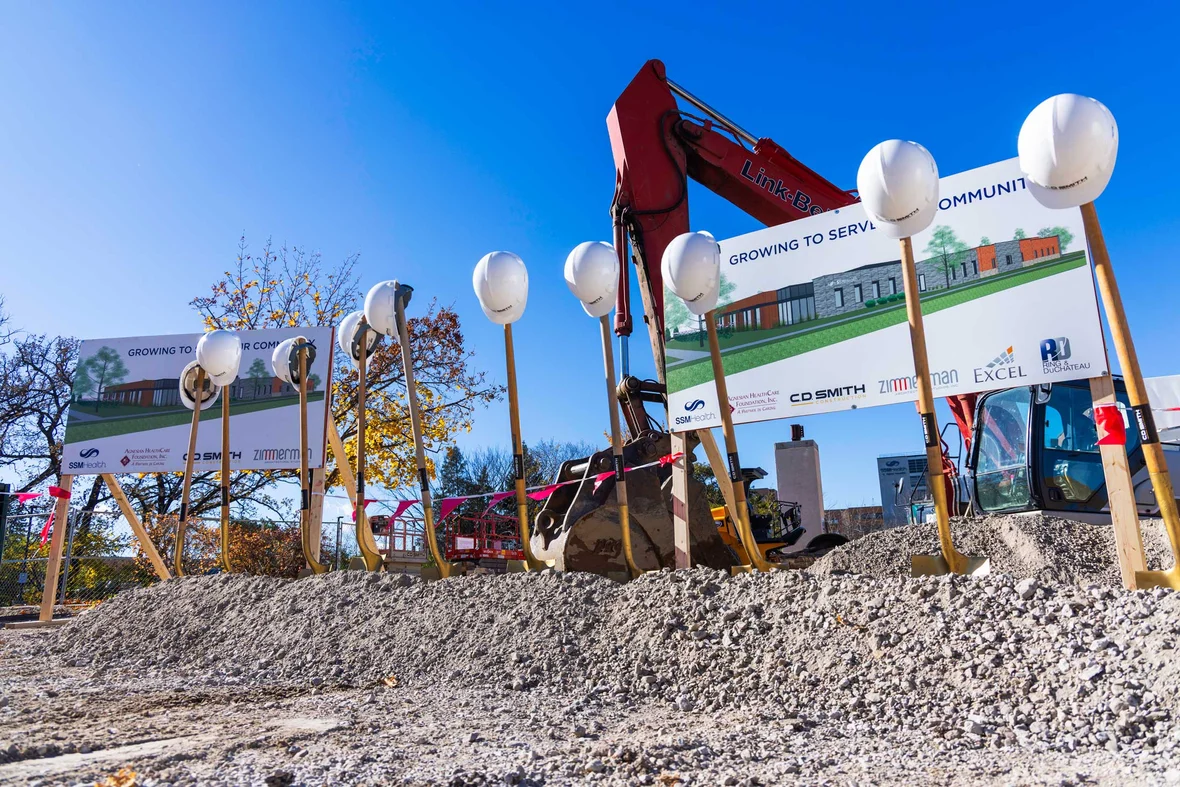 Hard hats and ceremonial shovels arranged in front of project signage at the SSM Health Cancer Center expansion site.
