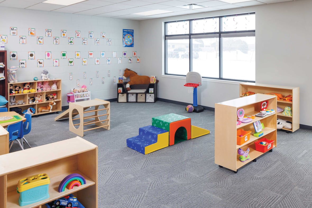 Pre-K play-based learning classroom with toys, alphabet wall, and activity centers