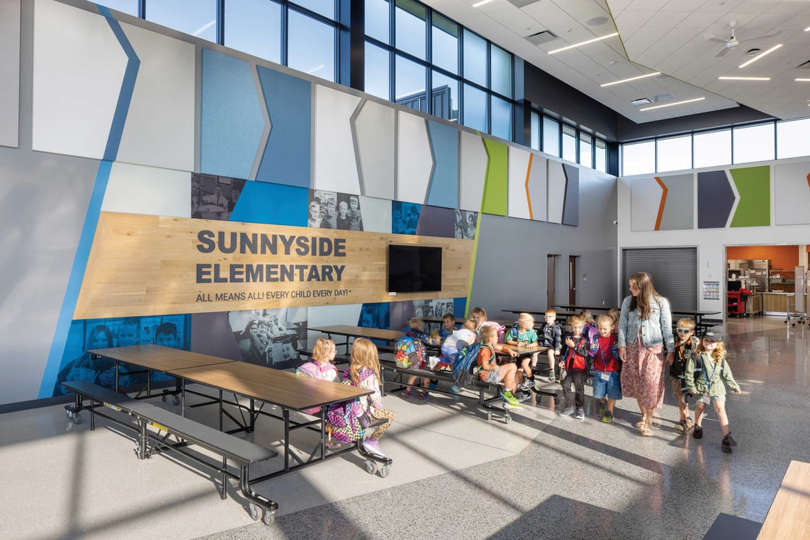 Students and staff using the Sunnyside Elementary School commons and cafeteria filled with natural light