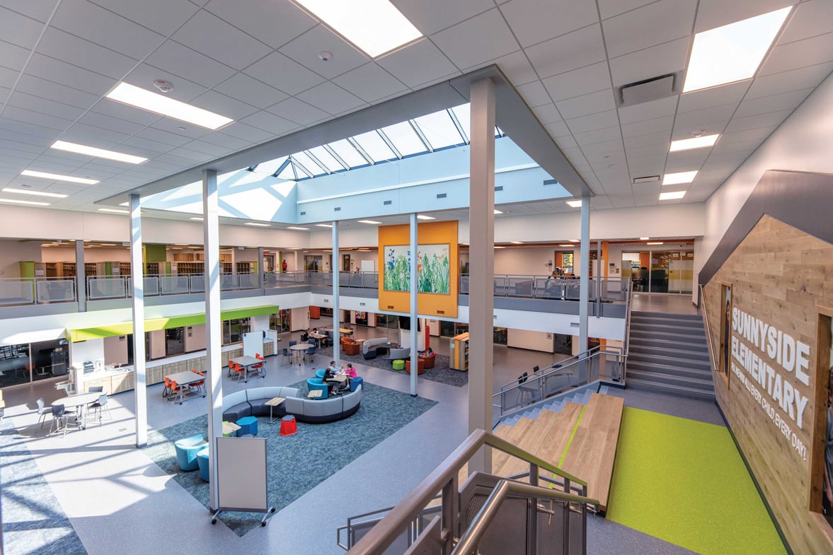 Student collaboration hub at Sunnyside Elementary School with central skylight bringing natural light into shared learning space
