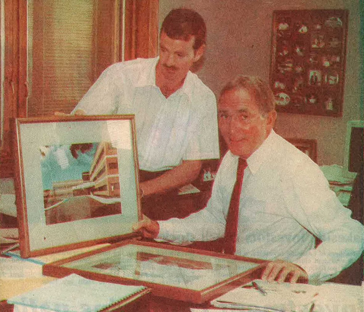 Tom Baker Sr. President and Gary Smith Vice President of C.D. Smith Construction reviewing a framed project photo in 1995.